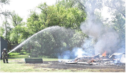 A shed started on fire near 439th Ave. east of Webster May 28. Waubay and Webster Fire Departments were called to scene. No report was available as of press deadline. Here, Webster fire fighter Leonard Deibert takes action to help put out the flames. Reporter &amp; Farmer | Connor Handrahan