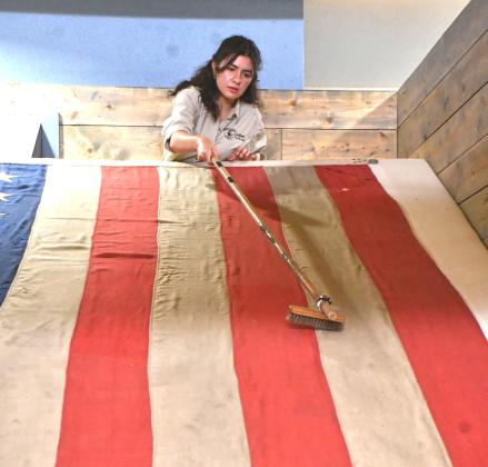 Mia Higginbotham, Museum Director Intern at Fort Sisseton Historic State Park, cleans the 38-star American flag which flew over the fort during its final days as a military post in 1889. This summer, Higginbotham gave the flag its first conservatory cleaning since it was first displayed in 2014. Reporter &amp;amp; Farmer | Timothy Gibson