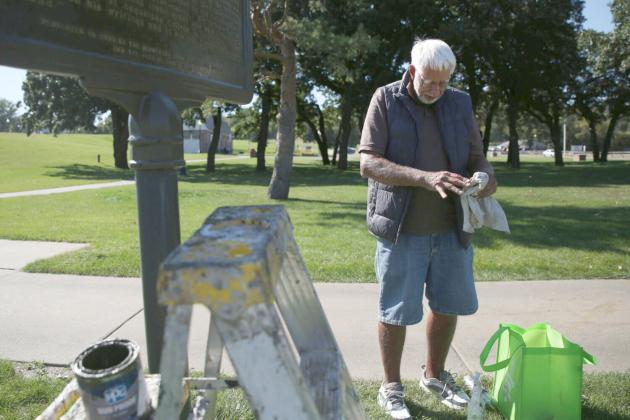 Jim Carlson, with the Minnehaha County Historical Society, repaints a historical marker at Falls Park in Sioux Falls Sept. 23. Reporter &amp;amp; Farmer | Makenzie Huber/South Dakota Searchlight