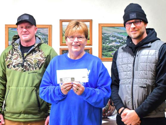 Middle, Patti Mitchell presented, left, Jason Baker and Chris Stevenson receive first place prize from Patti Mitchell for most number of coyote brought in. Baker and Stevenson brought in 26 out of the 52 coyote hunted during the Day County Coyote Hunt Dec. 14. Reporter &amp;amp; Farmer | Connor Handrahan