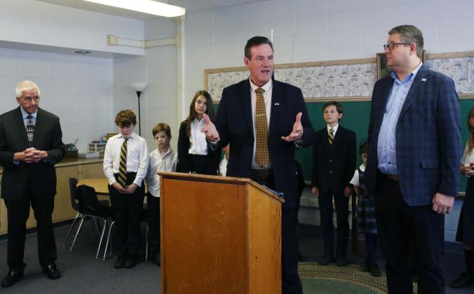 South Dakota Gov. Larry Rhoden speaks to media during an announcement at the St. Joseph Academy in Sioux Falls Nov. 11. State Education Secretary Joe Graves (left), Lt. Gov. Tony Venhuizen (right) and St. Joseph Academy students stand around him. Reporter &amp;amp; Farmer | Makenzie Huber for South Dakota Searchlight
