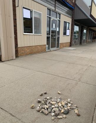 Rocks pictured Sept. 15 on Main St. in Webster were thrown from atop businesses towards adjacent businesses by two juveniles who were apprehended the night of Sept. 14. Two of the windows pictured at 508 Main St. were broken and patched. Reporter &amp;amp; Farmer | Amanda Dulitz