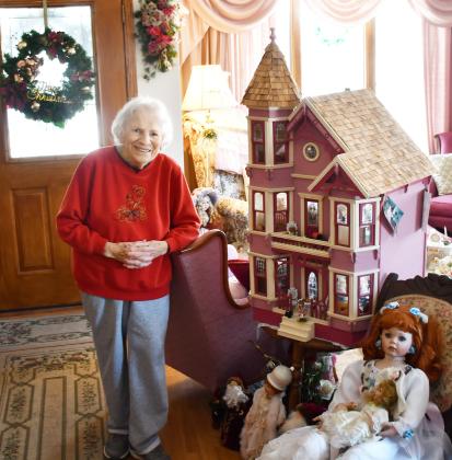 Having a collection spanning back to her childhood, 88 year-old Anna May Carlis has a collection of over 100 dolls. Here, Dec. 7, Carlis stands next to a handcrafted doll house which her late husband Glen made for her and one of the dolls in her collection. Reporter &amp;amp; Farmer | Brenner Cariveau