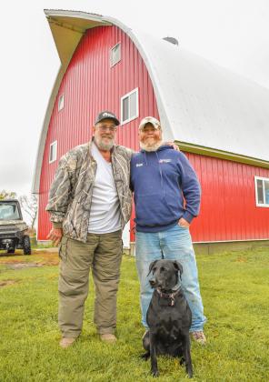 (At right) Webster area resident, from left, Bruce Knowlan, Josh Anderson, Webster and Knowlan’s dog Hazy pose in front of Knowlan’s historic gothic arch barn Oct. 14. The 1951 barn saw significant upgrades from 2015-16 including new siding and roof. Knowlan, who owns the barn with his wife Annie, employed the help of Anderson for the project. Reporter &amp;amp; Farmer | Leyton Beardslee