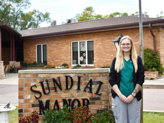 Jenaica Hunt stands next to the Sun Dial Manor sign in Bristol after becoming the new director of nursing Sept. 9. Hunt, graduated from Webster Area High School in 2015 and later went on to complete her post secondary education at Southeast Technical College in Sioux Falls in 2023. Reporter &amp;amp; Farmer | Brenner Cariveau