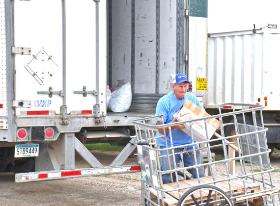In last week’s issue, an article was published about a mysterious trailer that appeared in the farmer market’s parking lot and with help from a few community members, the trailer has been identified. Needs Anonymous has been using this trailer to collect their unsellable products and those donations will go to helping less fortunate people in Africa. Here, Howard Hvidsten can be seen loading items into the trailer. Reporter &amp;amp; Farmer | Connor Handrahan