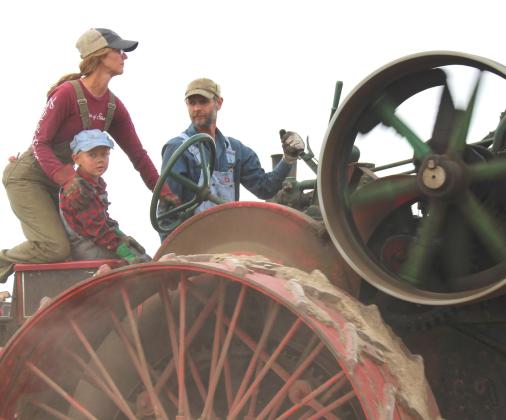 Jen Roth, left, drives an early 1920s 65-horsepower Case steam traction engine. Colt Edin, right, operates the gear shifter while Abram Edin, center, enjoys the ride Sept. 12 at Andover’s James Valley Threshing Show. See more photos throughout. Reporter &amp; Farmer | Timothy Gibson
