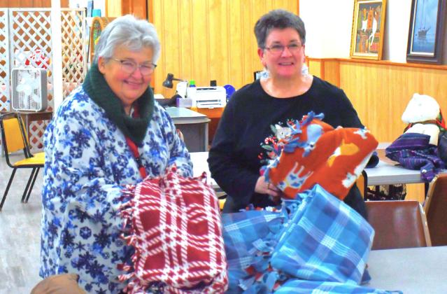 Blankets were tied at Day County Arts Center Christmas tree lighting event in Webster Nov. 30. Here, from left, Darlene Dulitz and Tandra Smidt announced the blankets will be donated to Sanford Hospital for people who need some way to stay warm during the cold winter. Reporter &amp;amp; Farmer | Connor Handrahan