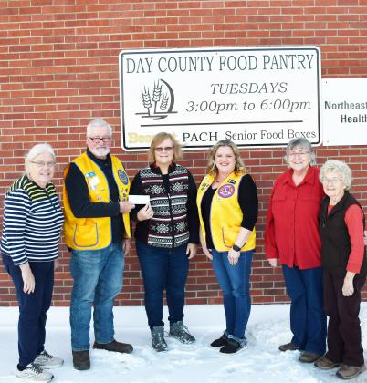 Eden Lions Club donated a check for $500 to the Day County Food Pantry Dec. 3. Pictured from left, Winnie Jacobs Day County Food Pantry volunteer, Dan Poss president of the Eden Lions Club, Margaret Kwasniewski Day County Food Pantry volunteer, Jannine Fagerland secretary of the Eden Lions Club, Mary Wagner and Carol Richardt Day County Food Pantry volunteers, stand in front of the Day County Food Pantry sign. Reporter &amp;amp; Farmer | Brenner Cariveau