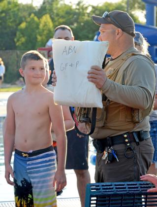Conservation officer Austin Norton explains a throwable flotation device to the group with volunteer Cruz Schafer at the Thrivent water safety event June 13. Reporter &amp;amp; Farmer | Annie Witt