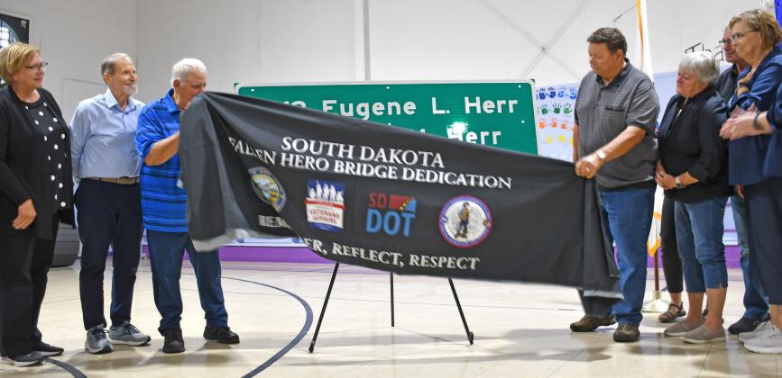 Members of the Herr family unveil the sign at an event at the Bristol gym last week, dedicated to the Herr brothers who died in the line of duty during World War II. From left are Susan (Herr) Hanson, Doug Herr, Rick Herr, Gene Herr, Karen (Herr) Kaml,Steve Hanson and Jackie (Herr) Hanson. Reporter &amp;amp; Farmer | Annie Witt