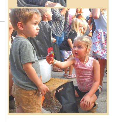 (BELOW) Candy was a hot topic among the youth who attended the demolition derby at the Day County Fair Aug. 8. Here, Blakelyn Eisenbraun offers Beckham Stepp some extra candy she had. Reporter &amp;amp; Farmer | Connor Handrahan