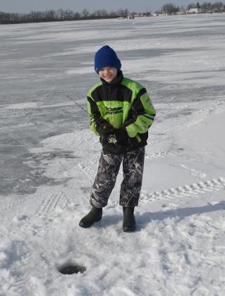 Knights of Columbus hosted the eighth annual ice fishing derby and raffle Feb. 22 at Enemy Swim Lake. Here, 11-year-old Owen Snaza from Webster attempts to catch a fish from an ice hole during the derby. Owen was accompanied by his father Nick Snaza.