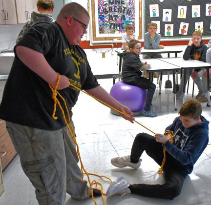 Webster Area School hosted a fishing lesson for third to seventh grade students Feb. 26 taught by Neenah High School in Wisconsin. In this class, students were taught the importance of ice safety. Front left, Tristan Powell and Cruz Shafer practice their rope rescuing. In back left, Tucker Aadland, Brasen Breske, Kannon Kwasniewski, Gunnar Lesnar watch the demonstration. Reporter &amp;amp; Farmer | Connor Handrahan