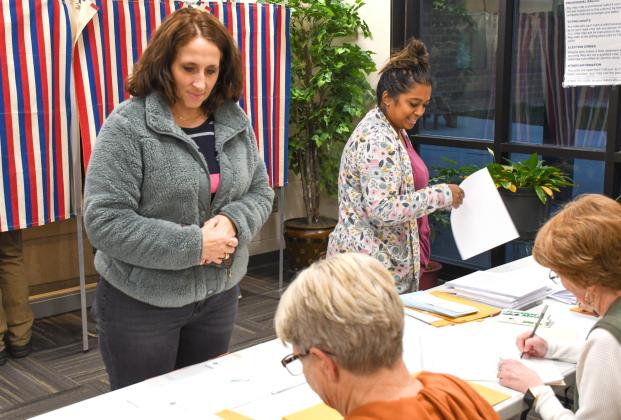 Jami Hubsch, left, and Kaylan Pool, right, each wait in line to cast their ballots Nov. 4 during Webster Area School District’s bond vote. Election officials Sandy Anderson, bottom left, and Bette Zenk, bottom right, helped record each voter who came to the polls that day. The 1,103 voters who cast their ballots represented a 42 percent voter turn out. The $12.5 million bond was ultimately voted down, 682-421. Reporter &amp;amp; Farmer | Amanda Dulitz