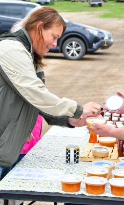 Tanya McCarlson takes a sample of creamed honey during farmers market in Webster, May 27. The market operates from 4-6 p.m. on Tuesdays. Reporter &amp;amp; Farmer | Leyton Beardslee