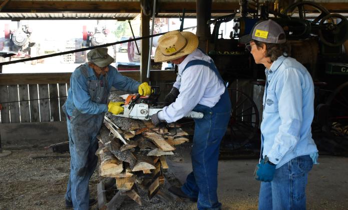 James Valley Threshing Show Sept. 6-8 hosted various antique agricultural equipment and other activities including an engine room, craft booths and a saw mill area in Andover. Starting on the left, Harris Billigmeier, Jeff Edin and Jane Larson are cutting lumber which would need to dry out. The processed lumber would then be used as the fuel source for the engine of the Case machine pictured behind the trio. Reporter &amp;amp; Farmer | Brenner Cariveau