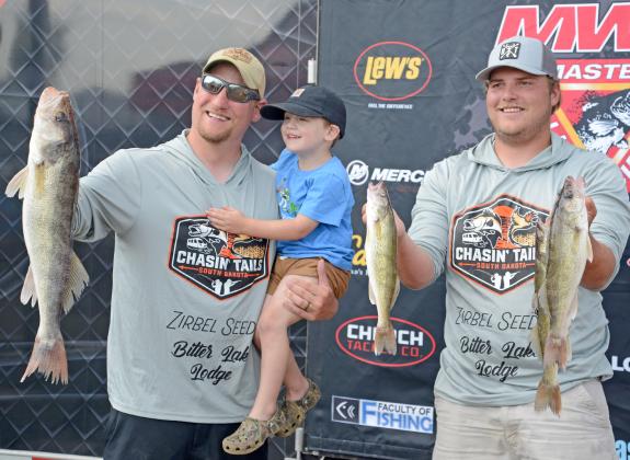 Showing off their fish from day two of the Masters Walleye Tournament are Waubay residents Joe Unzen with his three-year-old son Henry and his tournament partner Justin Zirbel. Reporter &amp;amp; Farmer | Amanda Dulitz