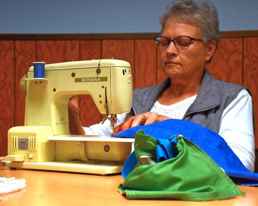 (Above) Sewing with a Purpose is a new group that helps create hygiene bags for young girls in South Africa. Journey of Faith is helping make this project possible and many church members have come to help with it. Here, Judy Williams starts sewing part of a bag’s exterior. Reporter &amp; Farmer | Connor Handrahan