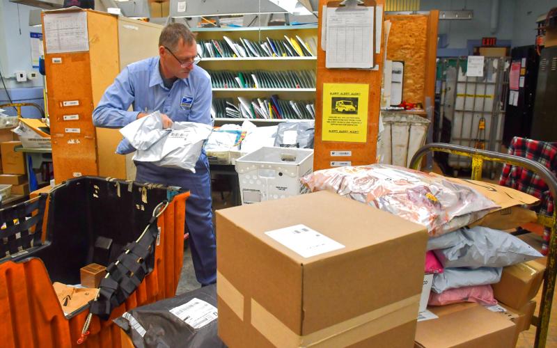 Randy Mount unloads several carts of parcells at the Webster Post Office Dec. 18. Mount has been working with the United States Postal Service as a city carrier in Webster for 28 years and plans to retire Dec. 26. Reporter &amp;amp; Farmer | Connor Handrahan