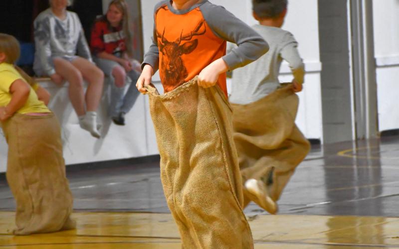 Landon Linde hops towards the potato-sack race finish line in the wrestling room during Webster Area School’s field day May 16. The field day was held indoors because of inclement weather. Reporter &amp;amp; Farmer | Leyton Beardslee