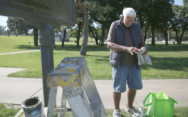 Jim Carlson, with the Minnehaha County Historical Society, repaints a historical marker at Falls Park in Sioux Falls Sept. 23. Reporter &amp;amp; Farmer | Makenzie Huber/South Dakota Searchlight