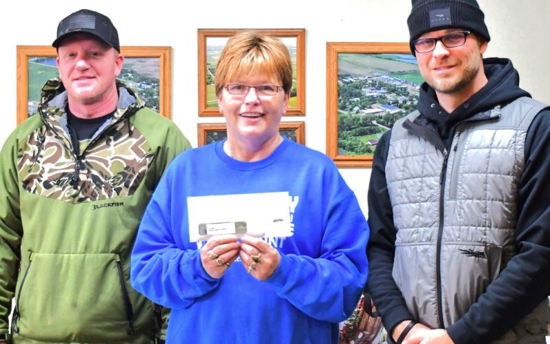 Middle, Patti Mitchell presented, left, Jason Baker and Chris Stevenson receive first place prize from Patti Mitchell for most number of coyote brought in. Baker and Stevenson brought in 26 out of the 52 coyote hunted during the Day County Coyote Hunt Dec. 14. Reporter &amp;amp; Farmer | Connor Handrahan