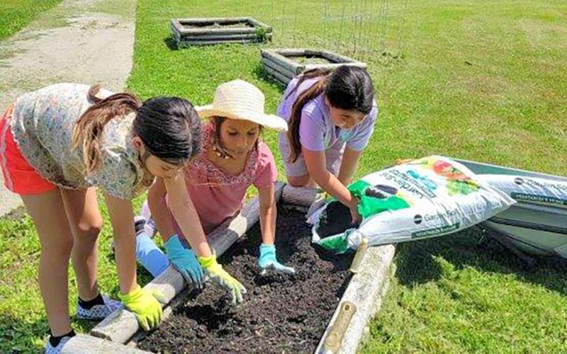 Students of the Toka Nawan Wayawa Tipi (translation: Enemy Swim Day School) Out of School Time program work on planting a garden at the school, located north of Waubay. Pictured from left are Marvalynn Redday, Amelia Simon and Mahpiya Gill. Reporter &amp;amp; Farmer | Subscriber snapshot