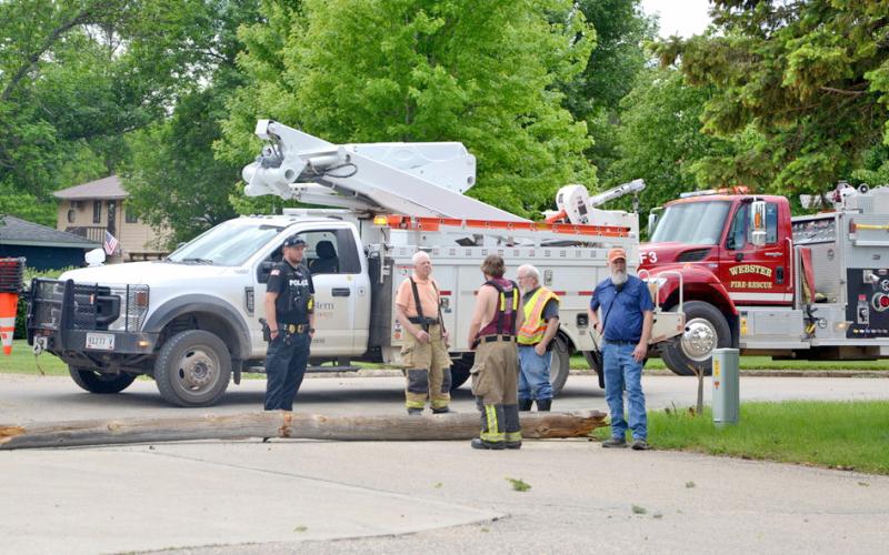 At the scene of where a service truck hooked an overhead cable causing a number of power lines and poles to go down in Webster June 7 stands Webster Police Chief Craig Baumgarn and Webster Volunteer firefighters Fritz Kwasniewski, Eric Kwasniewski, Wes Hoven and Austin Eisenbraun. Reporter &amp;amp; Farmer | Annie Witt
