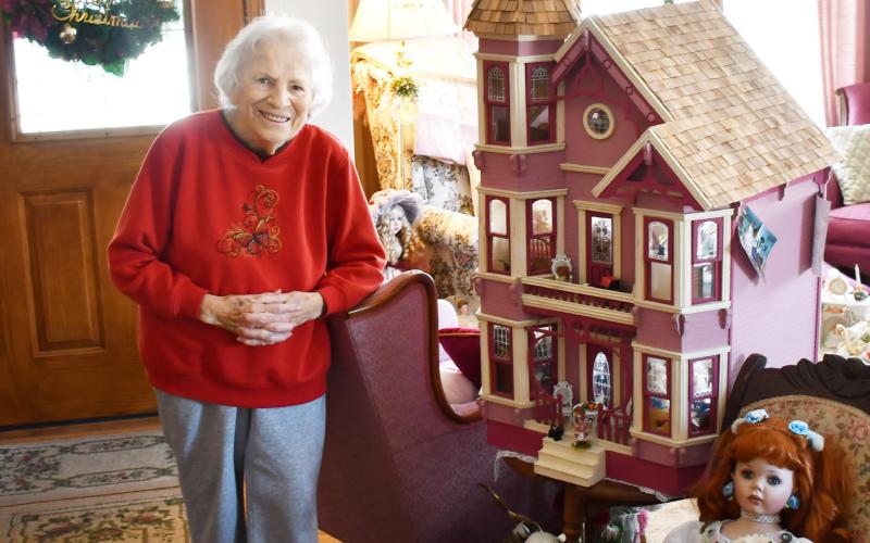 Having a collection spanning back to her childhood, 88 year-old Anna May Carlis has a collection of over 100 dolls. Here, Dec. 7, Carlis stands next to a handcrafted doll house which her late husband Glen made for her and one of the dolls in her collection. Reporter &amp;amp; Farmer | Brenner Cariveau