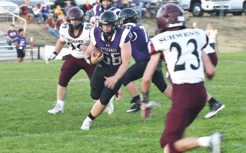 Senior running back Brooks Dolen (56) rushes the ball for the Waubay-Summit Mustangs as they faced off against the Wilmot Wolves Sept. 27. The Mustangs were able to secure their second win of the season with a score of 52-12 over Wilmot. Pictured behind Dolen is offensive lineman Will Althoff (77). Reporter &amp;amp; Farmer | Brenner Cariveau