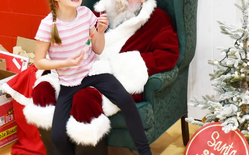 Roslyn booster club appreciation day took place Dec. 6 at the Roslyn Center in which a free meal was provided, inflatables for kids were present and Santa made an appearance. Here, eight-year-old Libby Huggett from Roslyn tells Santa her Christmas wishes which include an electric scooter. Taking Huggett to the event to meet Santa was her grandparents Melanie and Kim Remily. Reporter &amp;amp; Farmer | Brenner Cariveau
