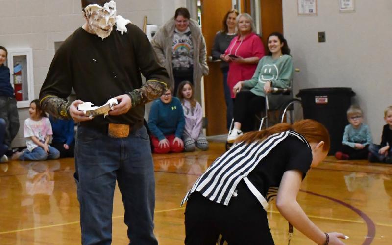 Webster Area School celebrated FFA week with a wheelchair basketball game Feb. 21 that provided the opportunity for a halftime show. Here from left, Blaise McGregor stands in shock after a plate of whipped cream smashed into his face by Chesney Deibert after McGregor was eliminated in a round of musical chairs.