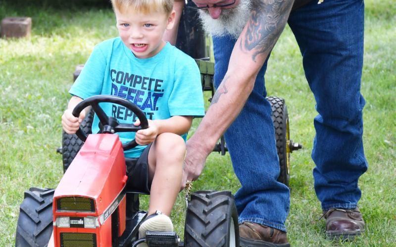The pedal pull was a major attraction for many Day County youth during the Day County Fair. Three-yearold Hux, son of Justin and Tarah McClurg, participated in the pedal pull Aug. 10. The young Webster native applies force to the heavy tractor as Russell Larson provides a gentle push. During the Day County Fair children wanted to prove their worth in the pedal pull event and earn a trophy for their hard work. Reporter &amp;amp; Farmer | Brenner Cariveau
