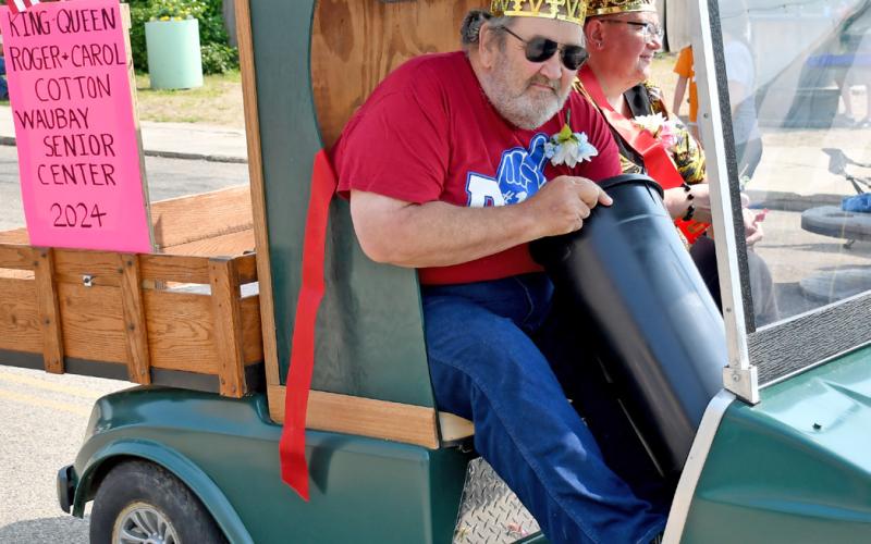 Roger and Carol Cotton were crowned the 2024 Waubay Senior Center King and Queen and were celebrated by participating in the parade during Waubay’s Fun Fest July 20. Here, Roger Cotton reaches into a bucket to pull out more candy to toss to eager parade goers. Reporter &amp;amp; Farmer | Amanda Dulitz