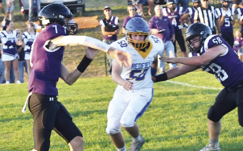 Sophomore Evan Aker (7) throws the ball against the Redfield Pheasants during Waubay-Summit’s homecoming contest against the Pheasants Sept. 20. Blocking for Aker is Caleb Miller (58). The Mustangs defeated the Pheasants 38-0. Reporter &amp;amp; Farmer | Brenner Cariveau