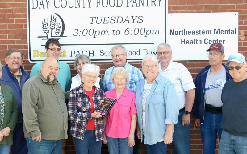 On her final day of volunteering at the Day County Food Pantry May 28, Louise Grajczyk was surrounded by coworkers-turned-friends who included fellow volunteers and area pastors. From left in back is Mike McCarlson, Tim Martin, Mary Wagner, Mike DeKraai, Lynn Lutz and Rick Hanson; from left in front is Susie Hanson, Clark Audiss, Louise Grajczyk, Carol Richardt, Winneva Jacobs and Denny Dugaard. Reporter &amp;amp; Farmer | Annie Witt