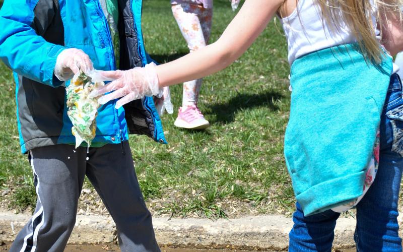 Levi Linde and Harlow Heupel, members of Webster Area Elementary kindergarden class, walked with classmates through the streets of Webster April 22 to clean up any garbage they found. Here, the pair work to clean up a sopping sandwich wrap which had gotten wet in the street. Reporter &amp;amp; Farmer | Amanda Dulitz