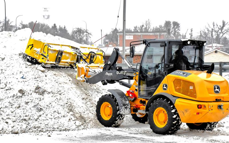 Avery Wyffels operates a piece of snow removal equipment Dec. 31 and piles snow in the back corner of a Webster business parking lot. He also helped move snow off roadways so drivers could motor safely following last week’s snowfall event. Reporter &amp;amp; Farmer | Connor Handrahan