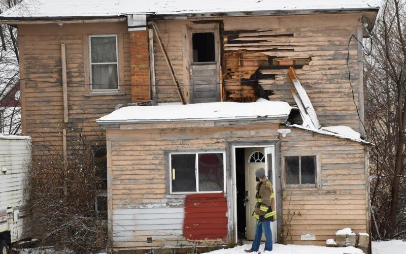 Firefighters revisited the 1106 Main St. house Dec. 10 accompanied by the Day County Sheriff and other men in hazmat suits. Fire Chief Robert Kwasniewski said no comment was available about the house due to the ongoing investigation. Here, Chris Gravley waits outside the back door during the visit of the home. The Main St. house was originally a part of a fire Sept. 9 with the cause of the fire never officially released. Reporter &amp;amp; Farmer | Brenner Cariveau