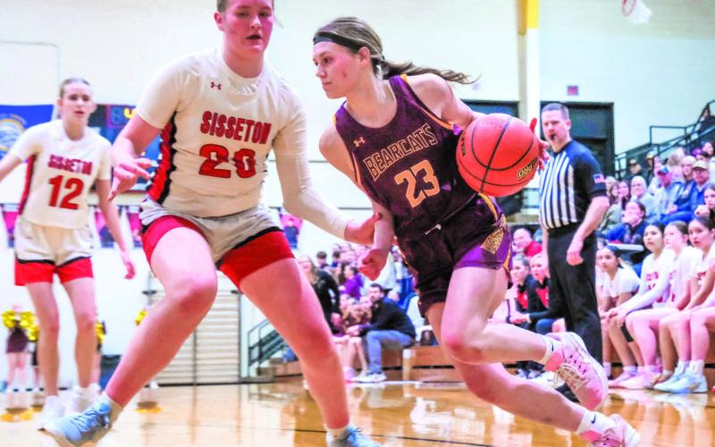 Cartney Hanson (23) of Webster Area drives past Piper Langager (20) of Sisseton Redmen during their playoff matchup Feb. 24 in Sisseton. Bearcats fell in the game with a final score of 35-70 ending their season. Reporter &amp;amp; Farmer | Leyton Beardslee