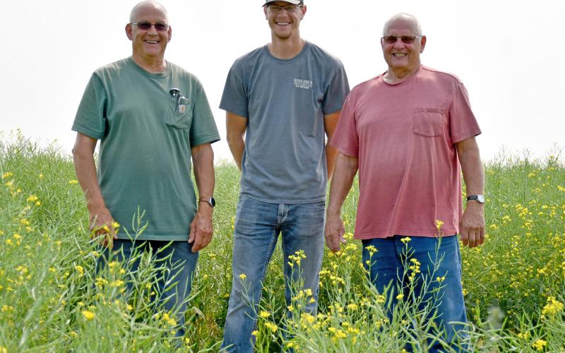 Standing in one of their fields of canola are Glenn Flattum, Gannon Florey and Butch Flattum in rural Bristol. Reporter &amp;amp; Farmer | Annie Witt