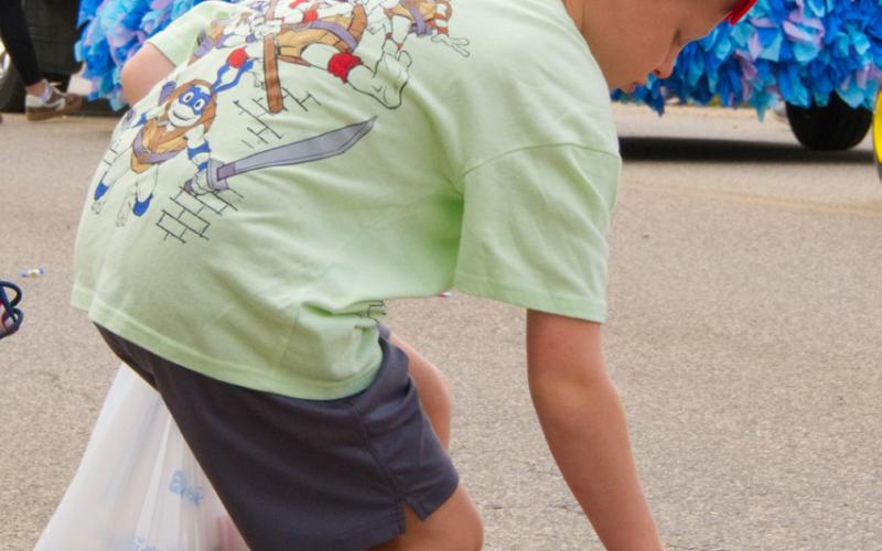 Barrett Cimburek of Mitchell picks up candy during the parade at Waubay Fun Fest July 19. The annual celebration draws hundreds of people every year to its festivities. Reporter &amp; Farmer | Leyton Beardslee