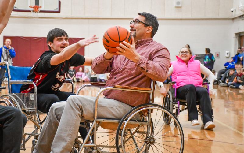 Webster Area third grade teacher Jared Vergeldt looks to shoot while being defended by student Jack Shoemaker during the annual wheelchair basketball game between Webster Area staff and FFA club members Feb. 25 at Webster Area High School. Students would go on to win the game 20-14. Reporter &amp;amp; Farmer | Leyton Beardslee