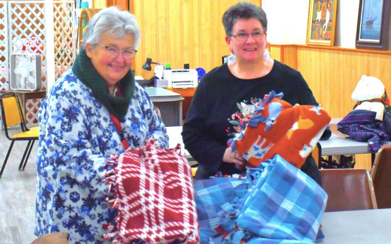 Blankets were tied at Day County Arts Center Christmas tree lighting event in Webster Nov. 30. Here, from left, Darlene Dulitz and Tandra Smidt announced the blankets will be donated to Sanford Hospital for people who need some way to stay warm during the cold winter. Reporter &amp;amp; Farmer | Connor Handrahan