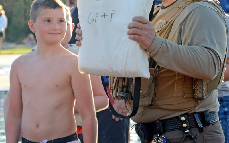 Conservation officer Austin Norton explains a throwable flotation device to the group with volunteer Cruz Schafer at the Thrivent water safety event June 13. Reporter &amp;amp; Farmer | Annie Witt