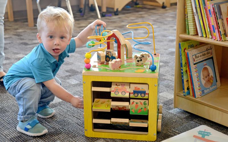 One-year-old Tye Siemonsma checks out one of the toys at the Knapp &amp; Play Learning Center during that facility’s community open house Sept. 3. The newly remodeled facility was set to begin taking in children by Sept. 8 and has been long-awaited in the community. Siemonsma, son of Paul and Christina Siemonsma of Webster, may become one of many new area youth to utilize the facility