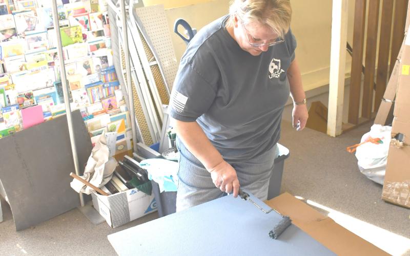 Needs Anonymous thrift store is undergoing renovations with the intention of re-opening March 29. Here, volun-teer Cathy Witzke helps paint shelving for the store March 12. Reporter &amp;amp; Farmer | Brenner Cariveau