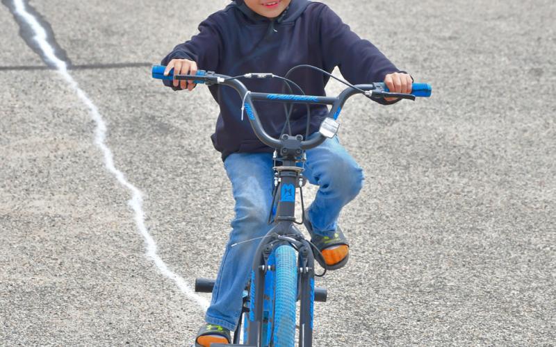Chad Anderson focuses on keeping his bike on the line during a bike rodeo in the Webster Armory parking lot May 27. The bike safety event was held in conjunction with Webster Public Library’s summer reading program. Reporter &amp;amp; Farmer | Leyton Beardslee
