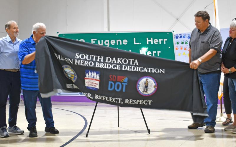 Members of the Herr family unveil the sign at an event at the Bristol gym last week, dedicated to the Herr brothers who died in the line of duty during World War II. From left are Susan (Herr) Hanson, Doug Herr, Rick Herr, Gene Herr, Karen (Herr) Kaml,Steve Hanson and Jackie (Herr) Hanson. Reporter &amp;amp; Farmer | Annie Witt